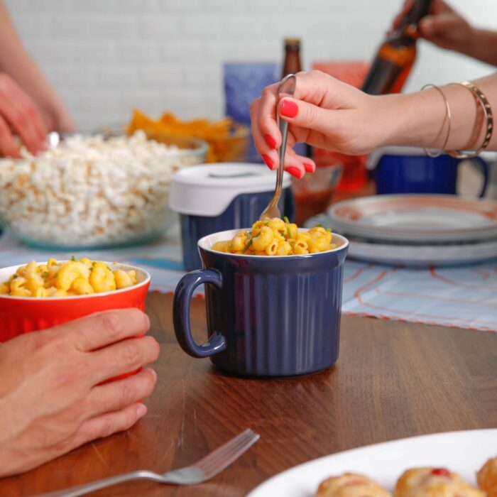 blue corning ware mug with macaroni featured at the center, with two more mugs out of focus