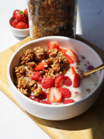 Easy Homemade Healthy Granola served in a white bowl with strawberries and yogurt