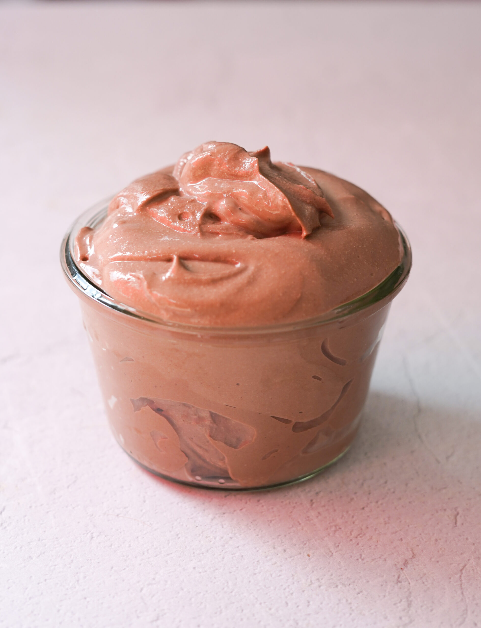 tofu chocolate mousse in a glass jar sitting on a white counter top