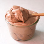 tofu chocolate mousse in a glass jar sitting on a white counter top