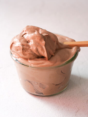 tofu chocolate mousse in a glass jar sitting on a white counter top