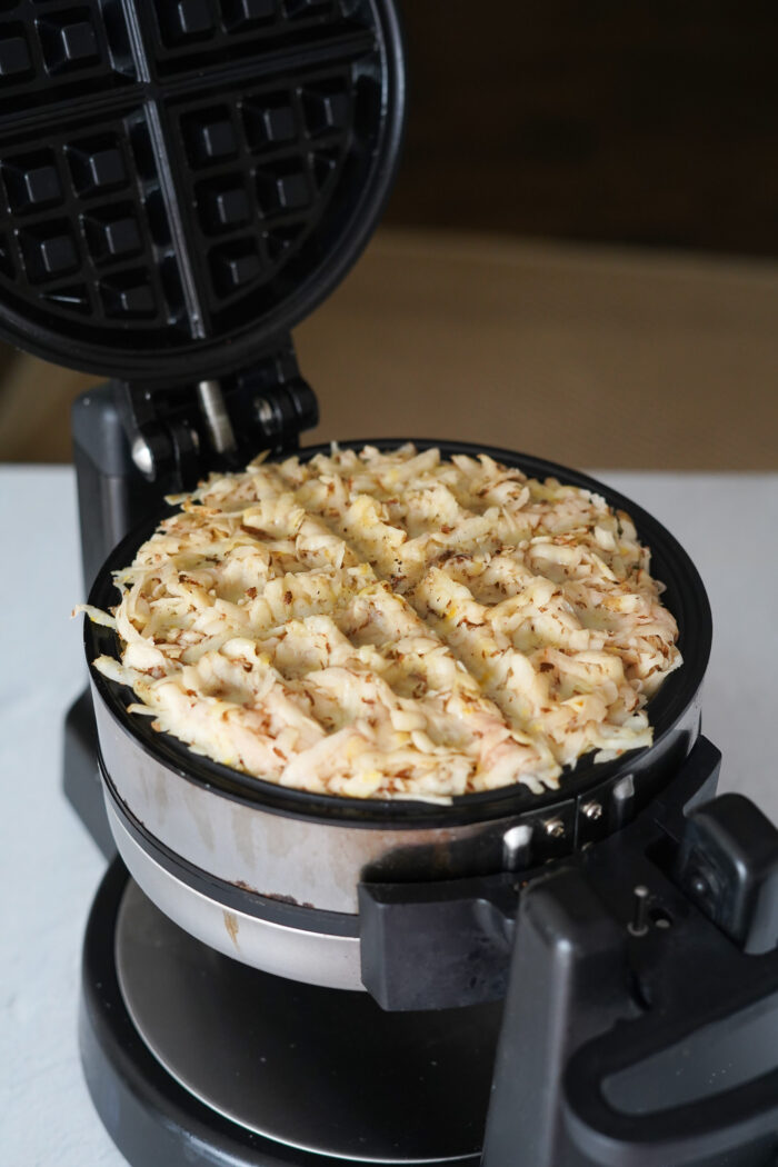 raw Waffle Maker Hash Browns mixture in the appliance