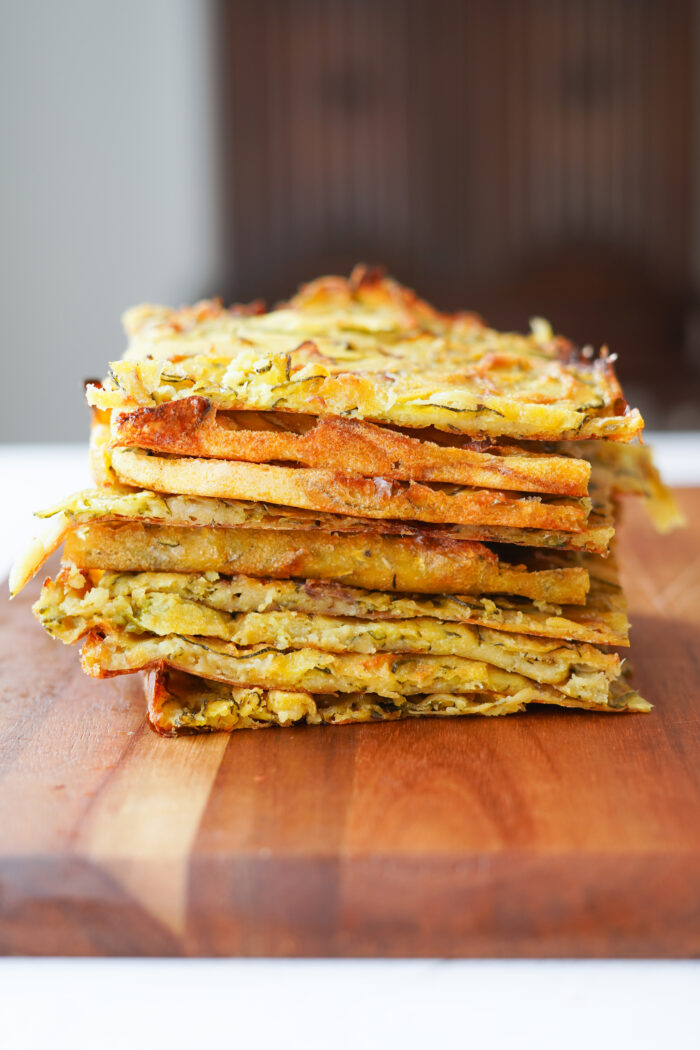 Scarpaccia Zucchini Tart sliced and stacked on a wooden cutting board