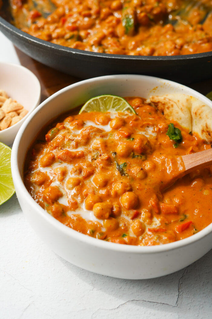 peanut butter curry served in a white bowl, pot in the background