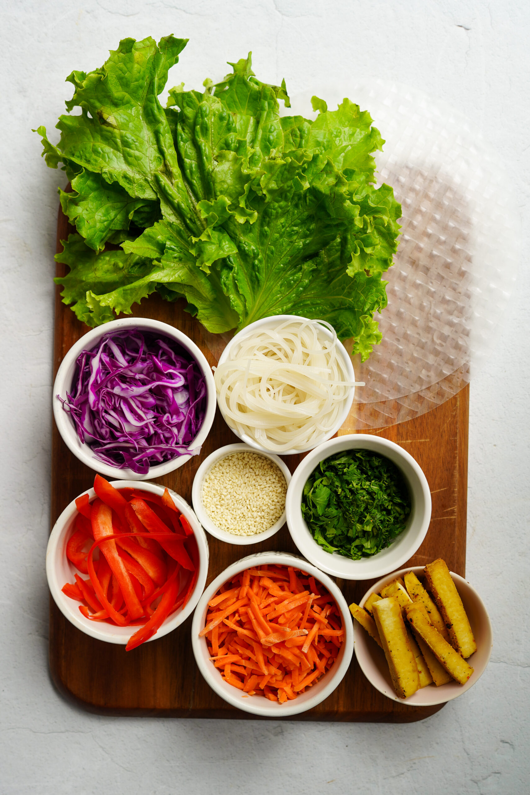 giant spring rolls ingredients laid out on a wooden cutting board