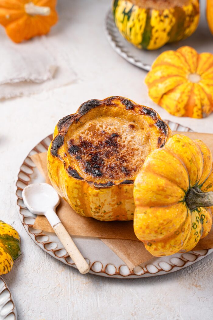 Mini pumpkin brulee served with a spoon.