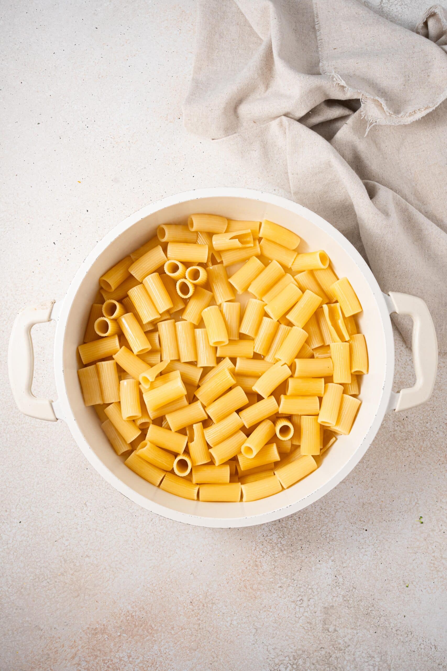 uncooked rigatoni in a white pot