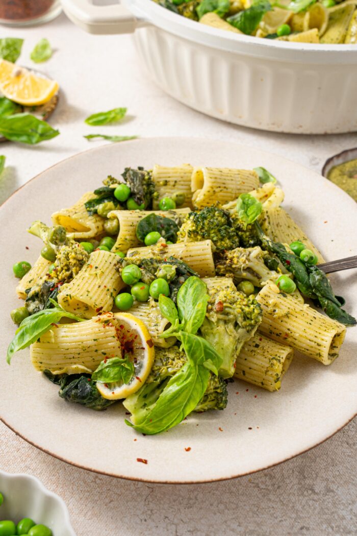 creamy one pot green pasta served on a plate topped with basil