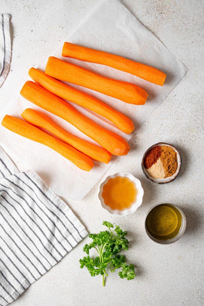 carrots and maple glaze ingredients laid out on a light background