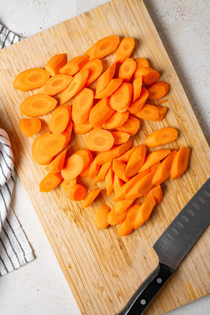 Carrots sliced on a wooden cutting board.