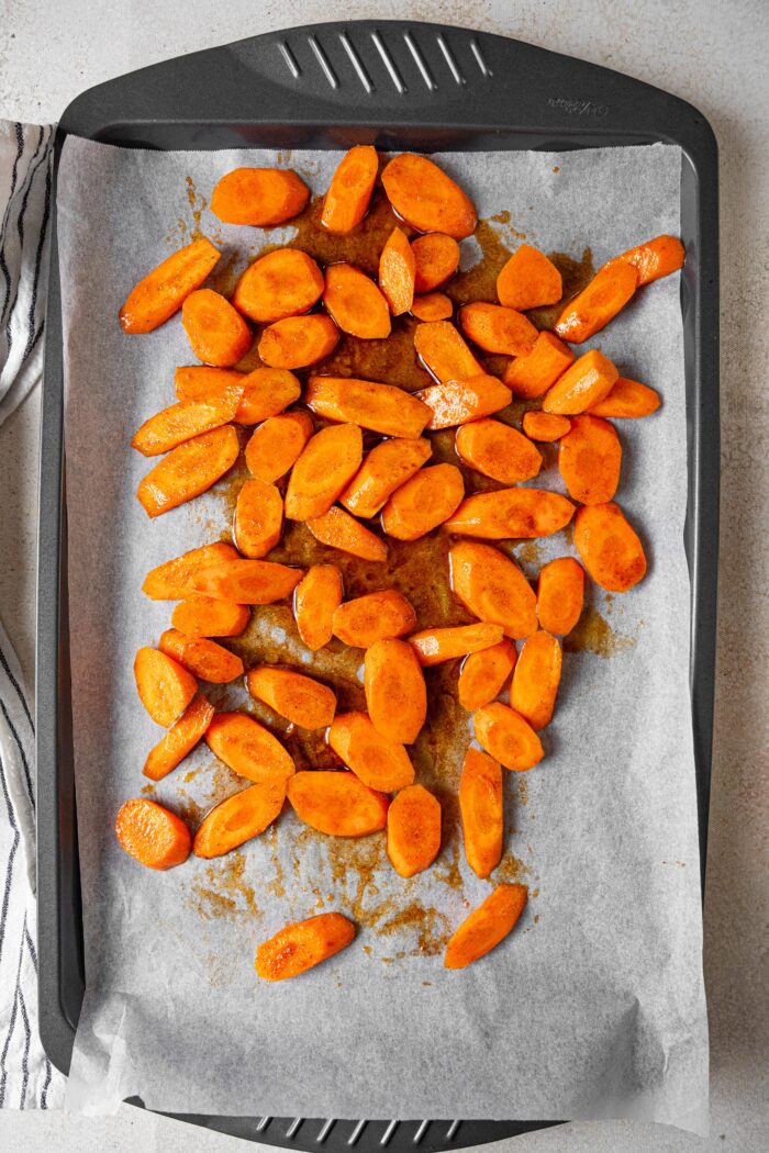 Carrots coated in the maple glaze and laid out on a lined baking parchment.
