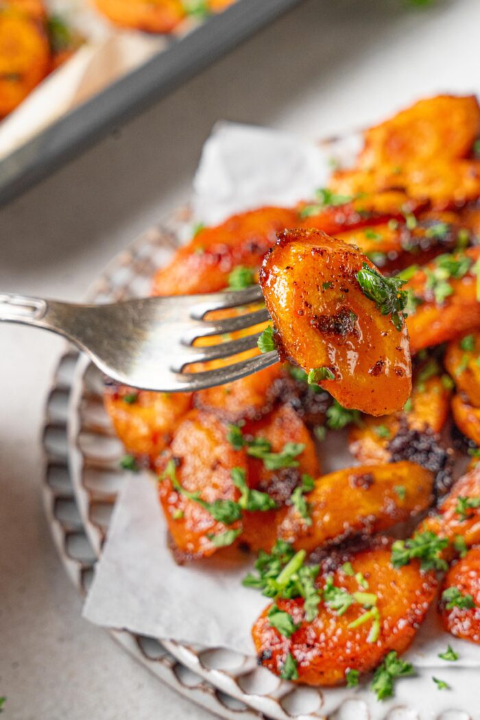 maple glaze carrots with parsley picked up by a fork