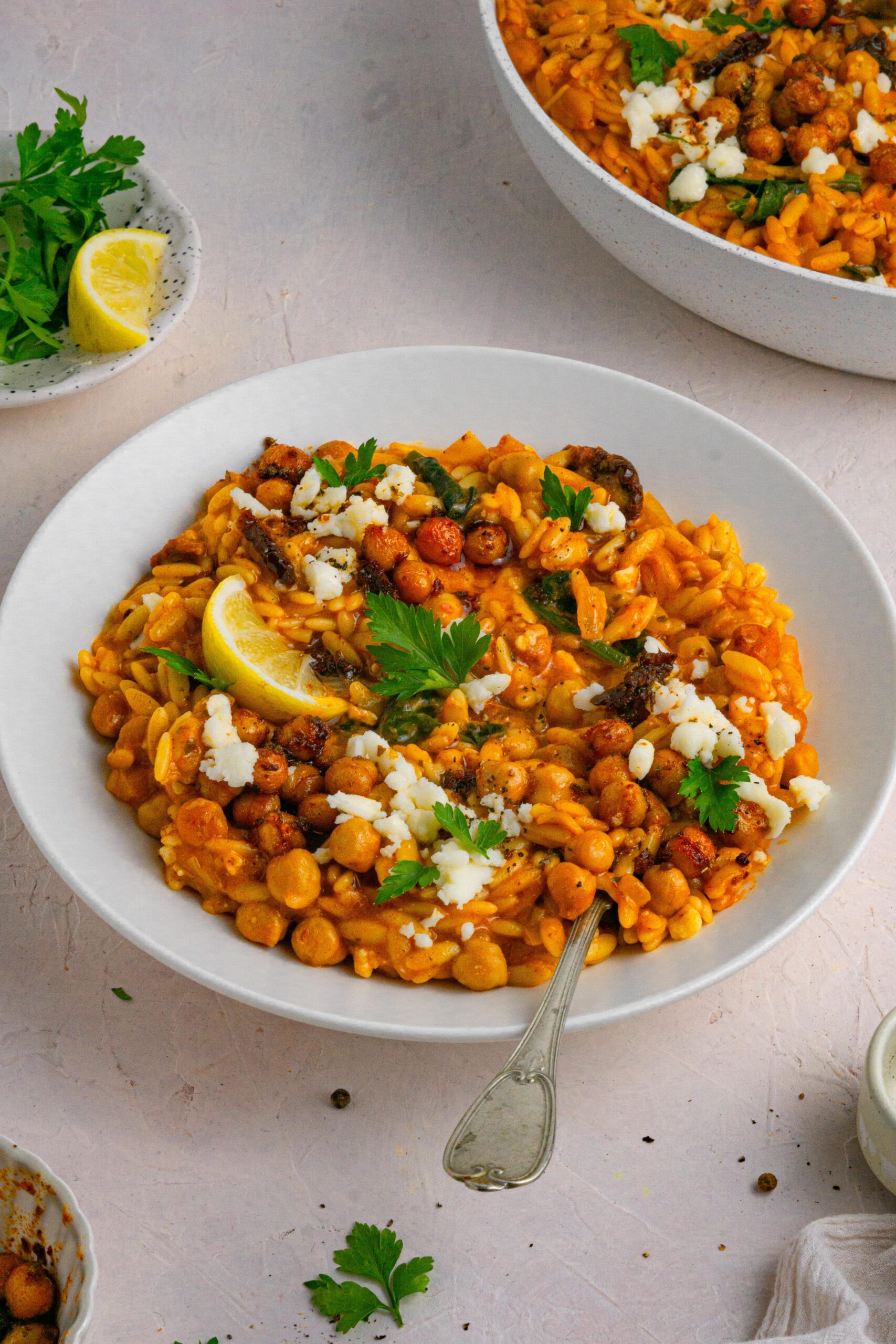 marry me sundried tomato orzo served in a white bowl with toppings