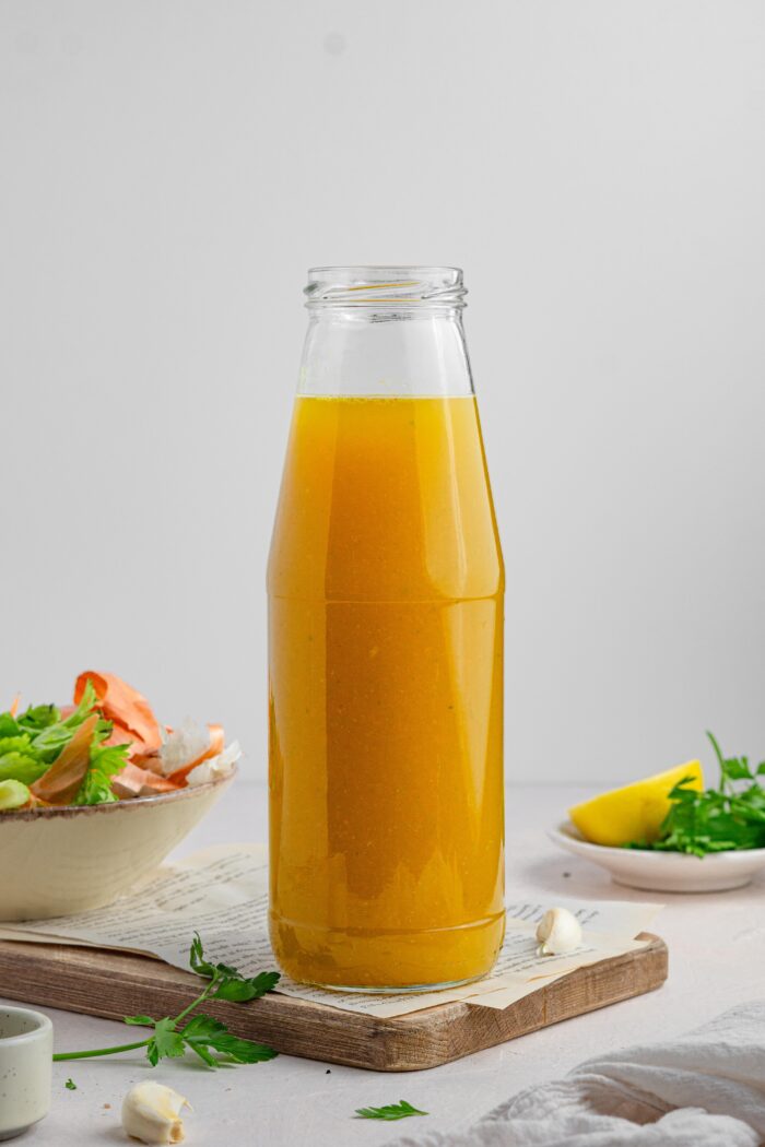 hidden veggie broth in a glass bottle with the ingredients in the background