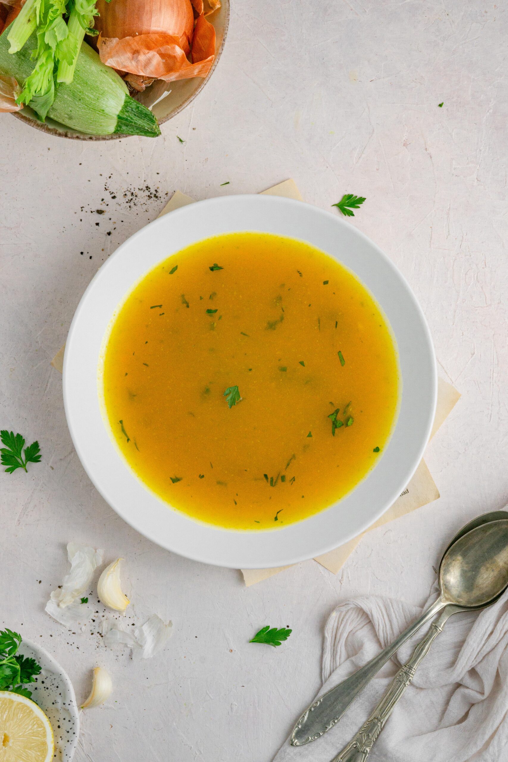 hidden veggie broth in a white bowl with some fresh parsley