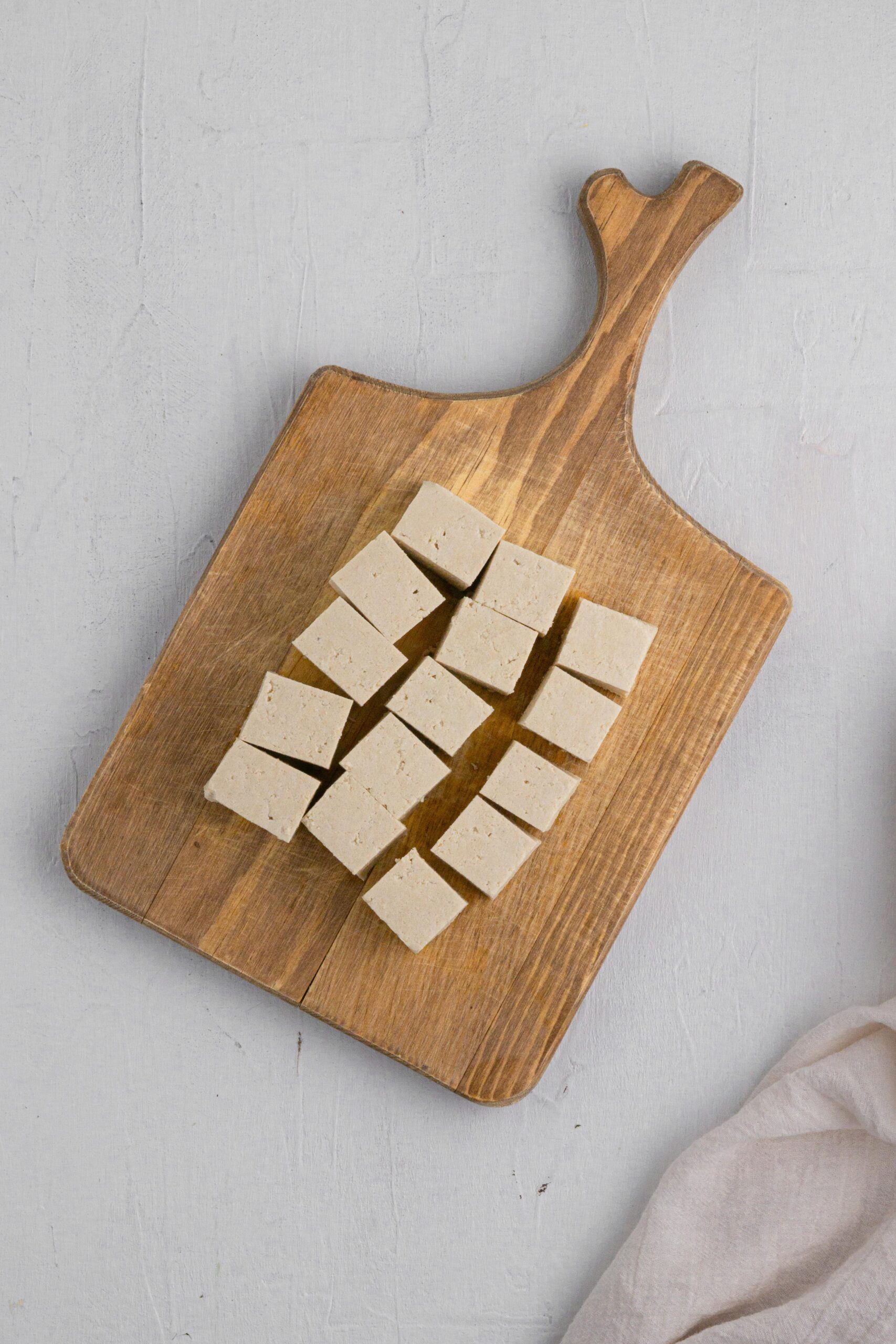 cubed tofuon a cutting board