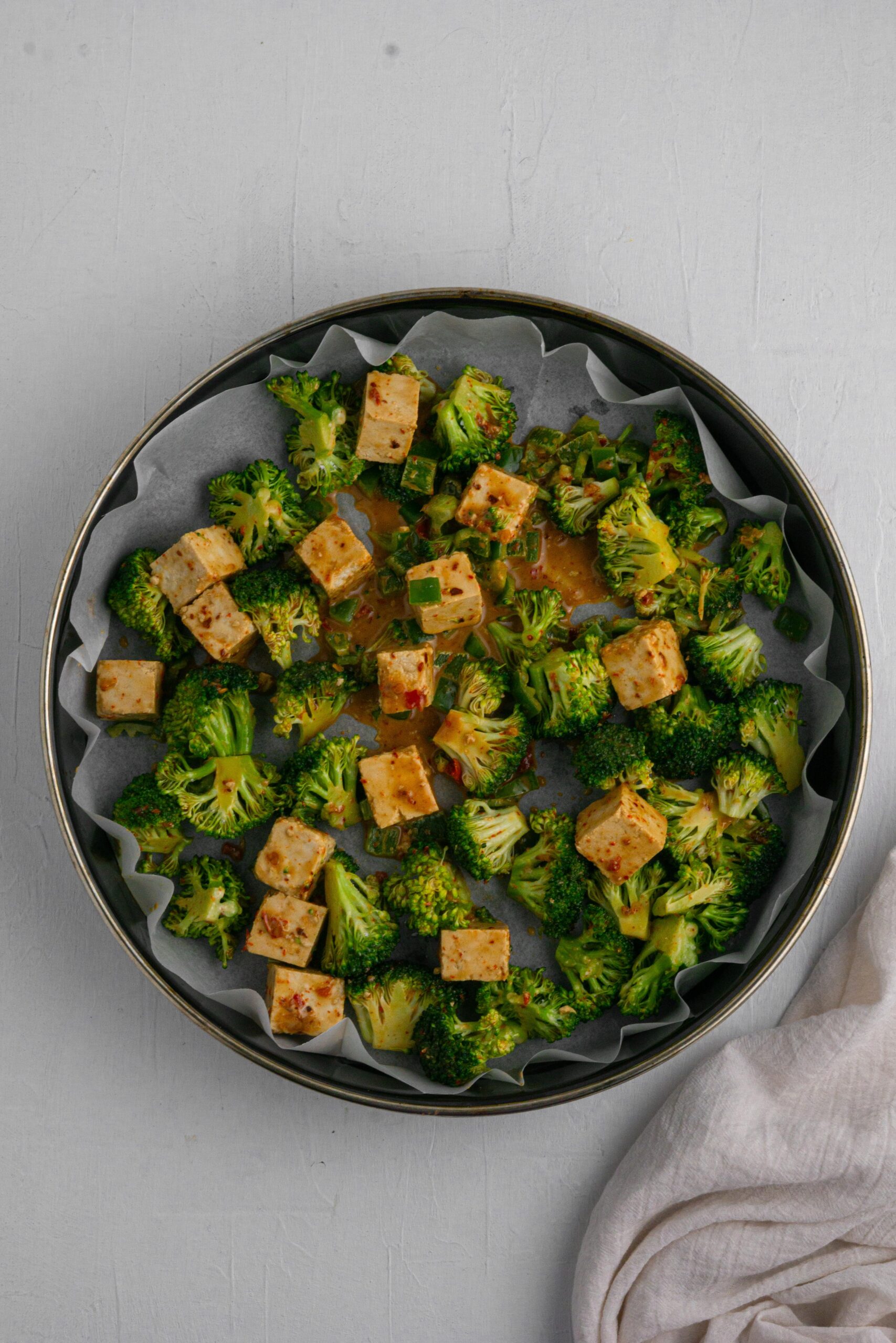 broccoli and tofu laid out in a lined baking sheet