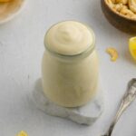 healthy vegan mayonnaise in a small jar on top of marble coaster