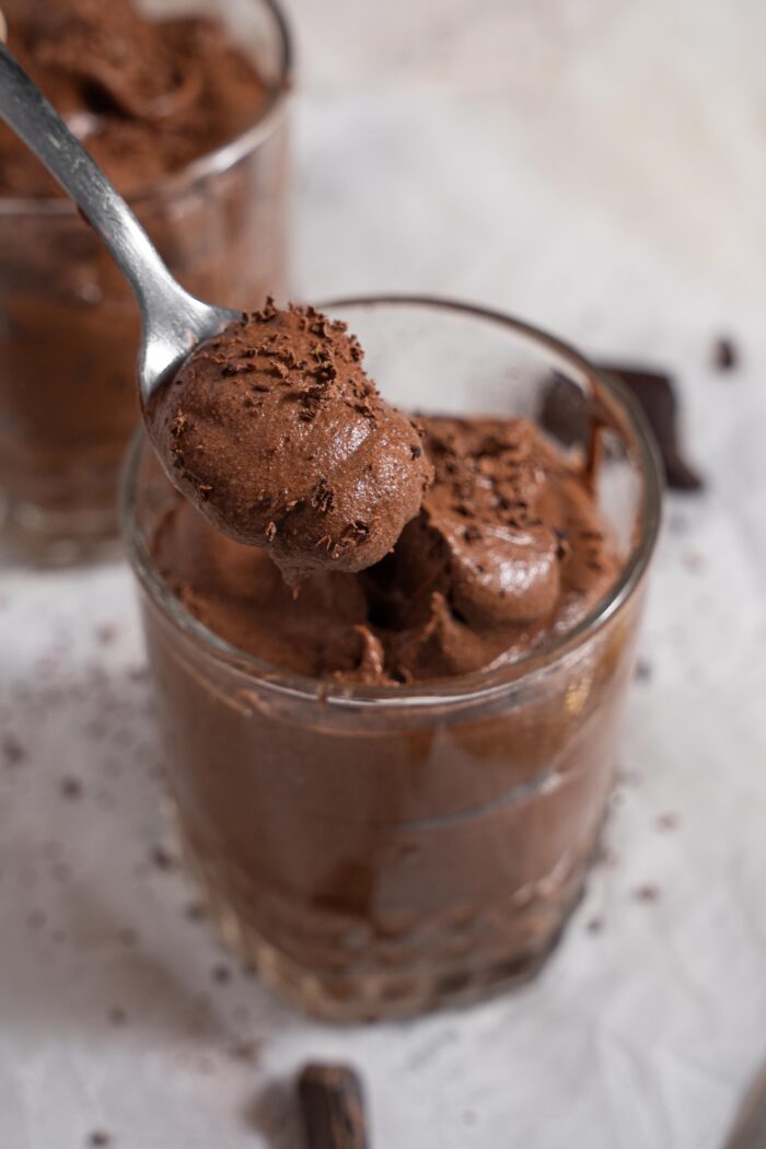 A spoonful chocolate mousse lifted from the pudding cup.