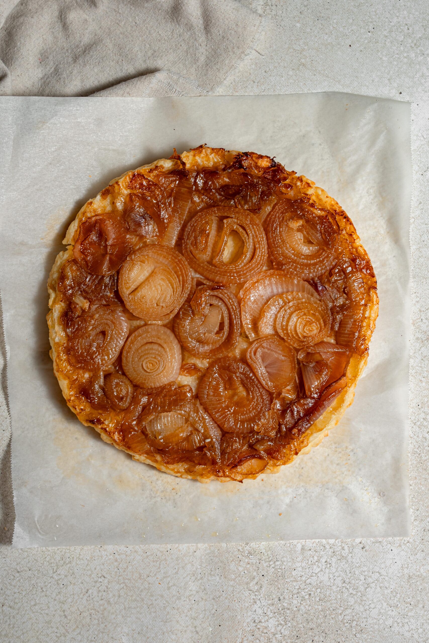 upside down caramelized onion tart on baking parchment