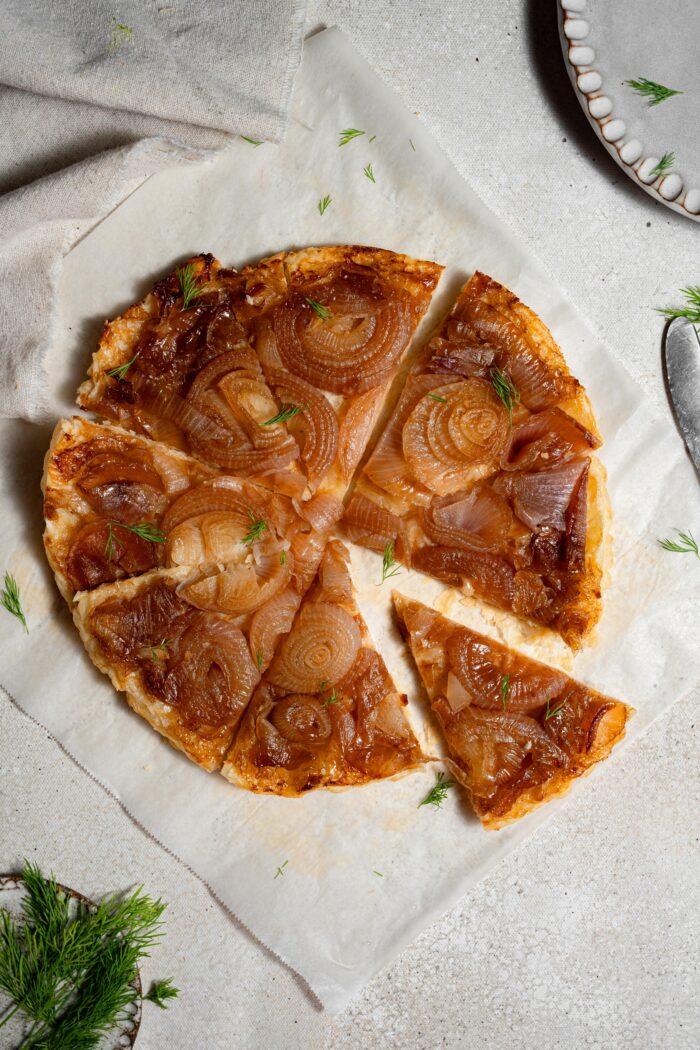 caramelized onion tart sliced and served with fresh dill