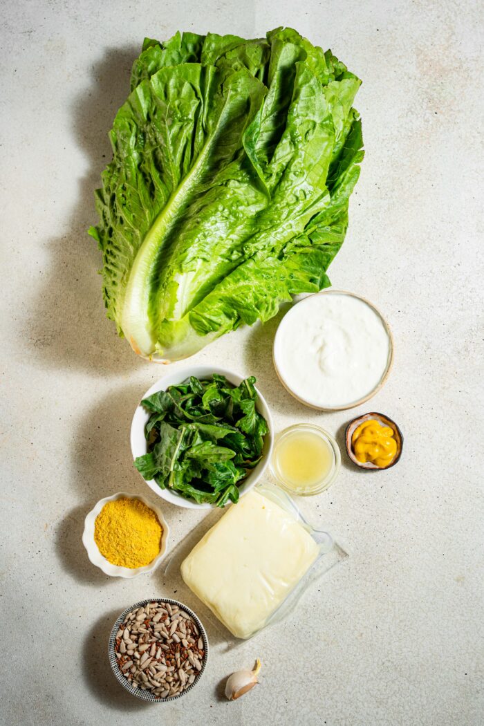ingredients for vegan caesar salad with crispy tofu laid out on light background