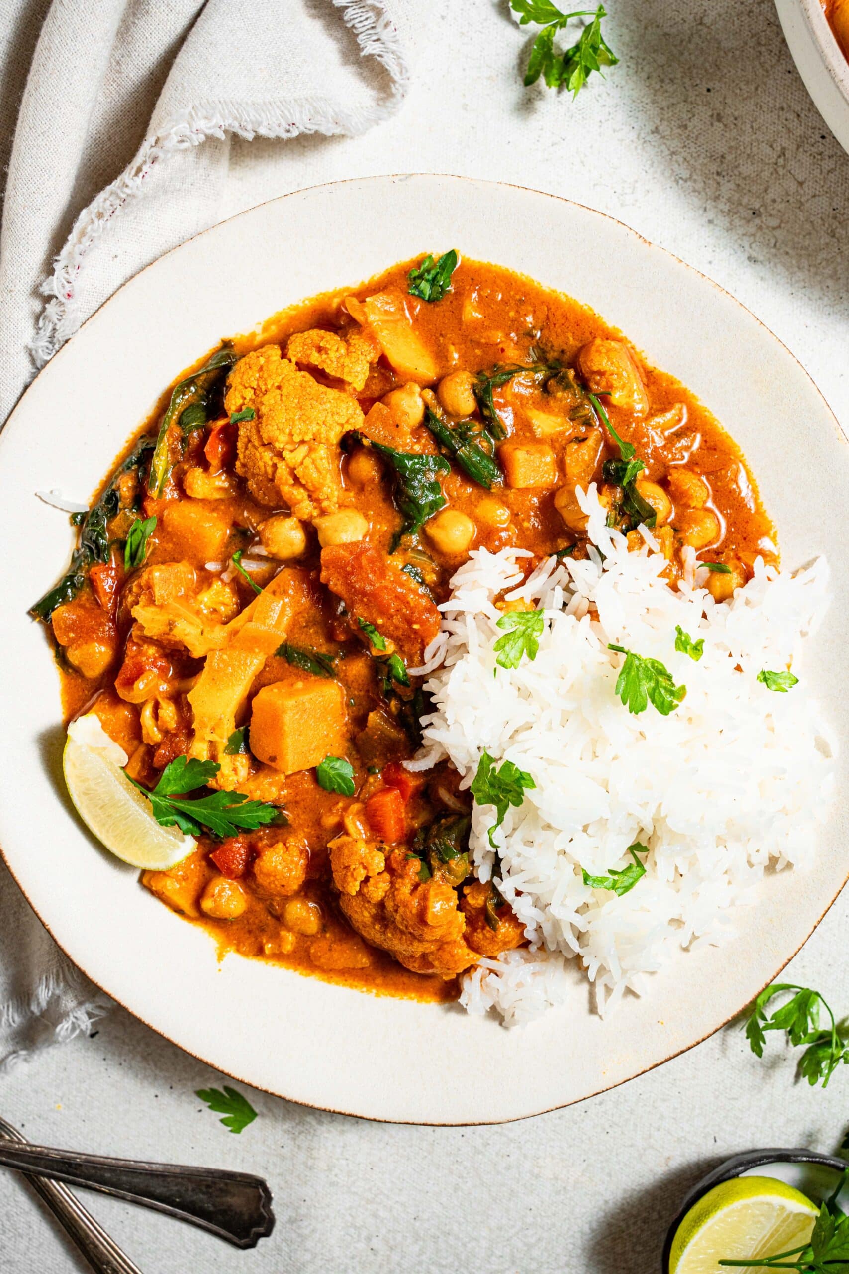 peanut stew with sweet potato cauliflower and chickpeas served with rice and parsley