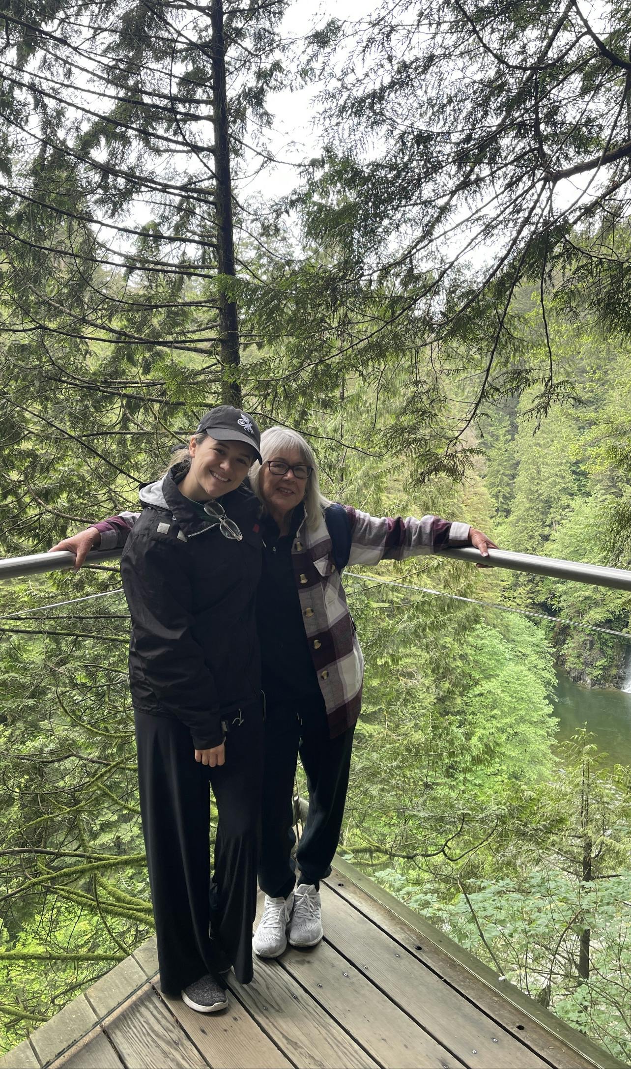 Carleigh and her mom Debbie on a terrace with pine trees in the background