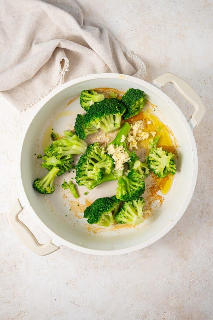 cooked broccoli in a pan with garlic oil and other ingredients