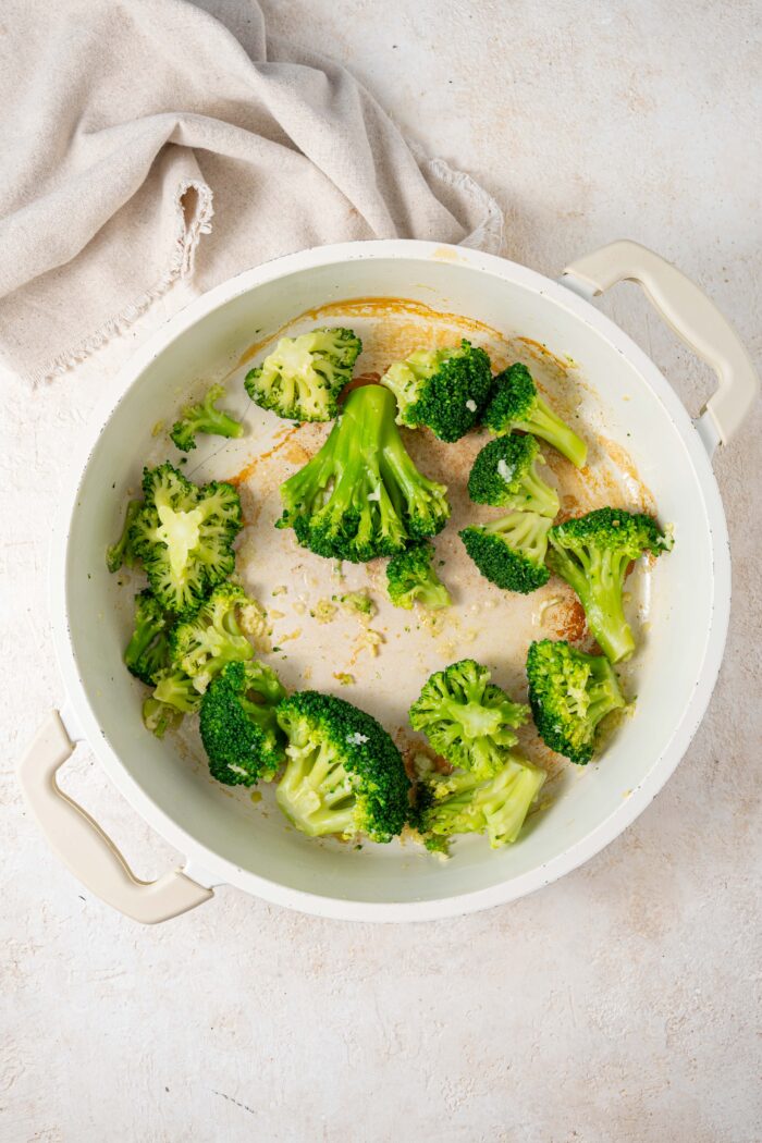 cooked broccoli in a pan sauteed with other sauce ingredients