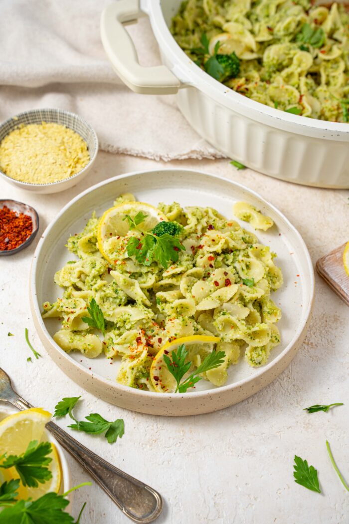 easy broccoli pasta served on a white plate with ingredients in the background