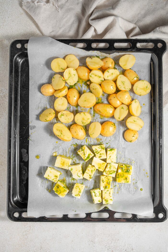potatoes and tofu on the baking sheet doused in lemon marinade