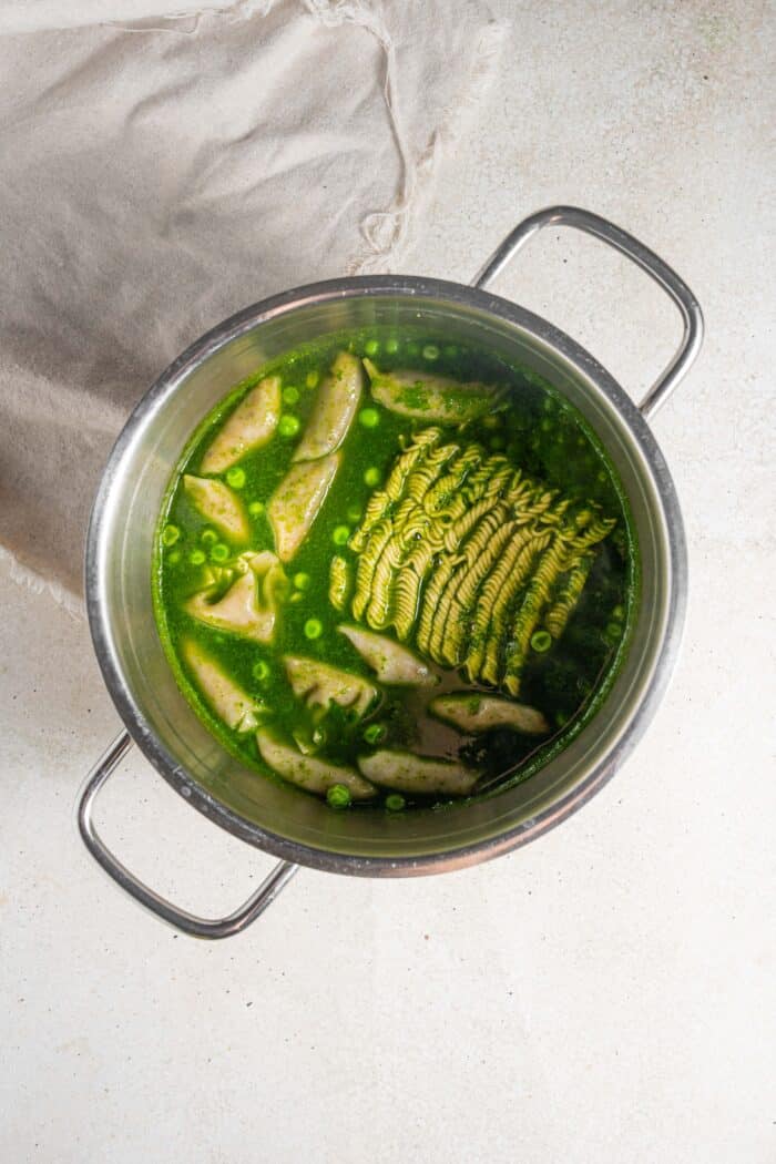 noodles and dumplings added to the green soup base