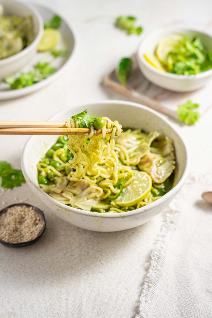 green spring dumpling soup served in a ramen bowl with chopsticks lifting some noodles