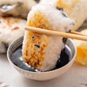 close shot of rice paper dumpling being dipped in soy sauce