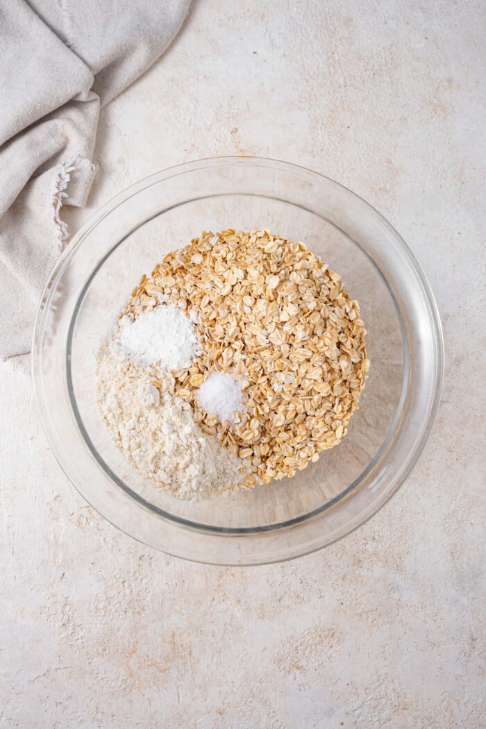 dry ingredients in a glass mixing bowl including oats, almond flour, salt and baking powder