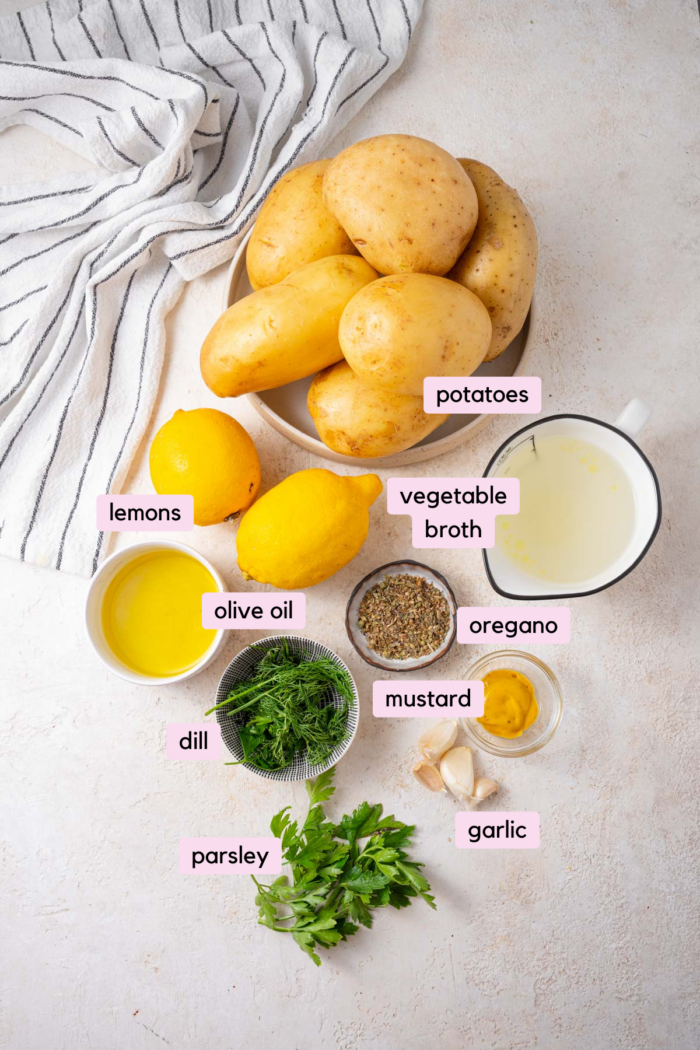 Greek potatoes ingredients laid out on a light background.