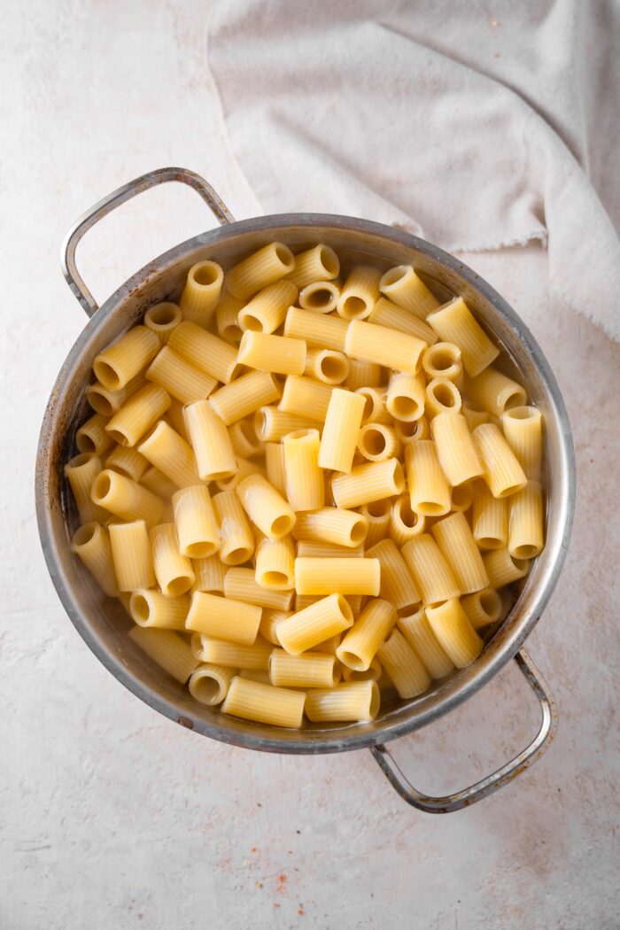 Cooked and drained rigatoni pasta in a steel pasta pot.