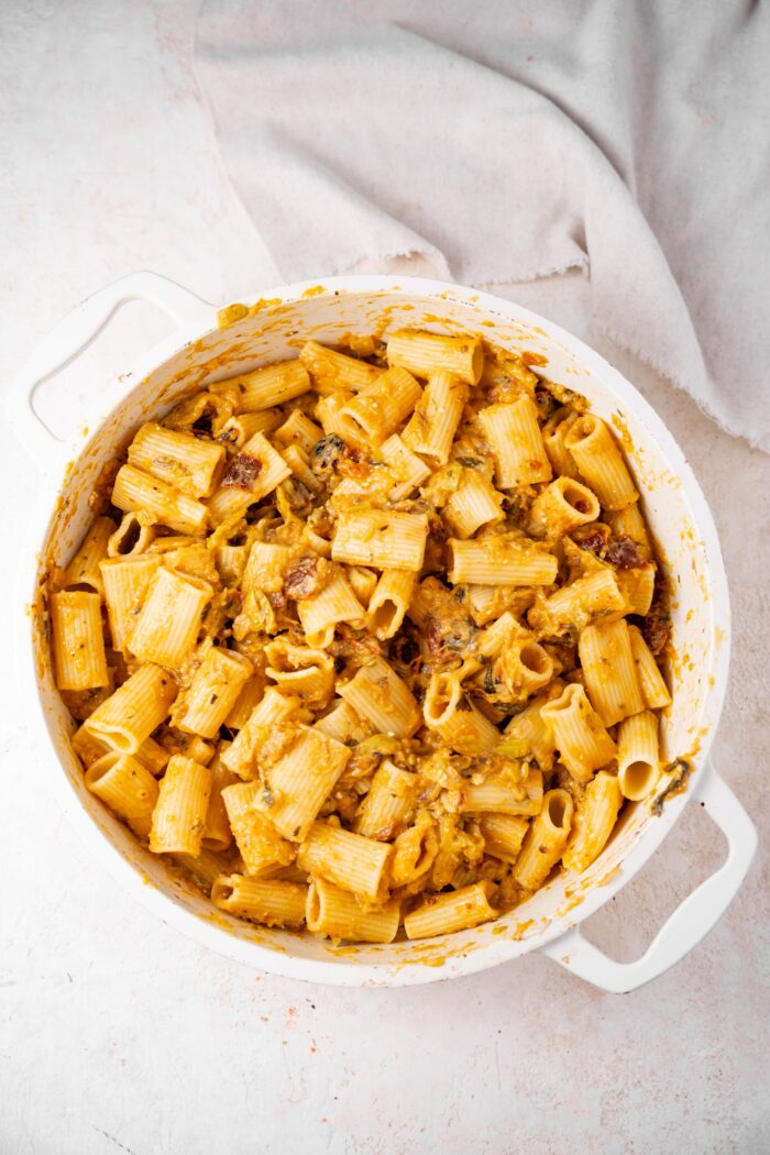 Rigatoni mixed with creamy zucchini lemon pasta sauce in the white casserole dish.