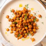 Vegan dill dip in a white bowl, topped with spiced crispy chickpeas.
