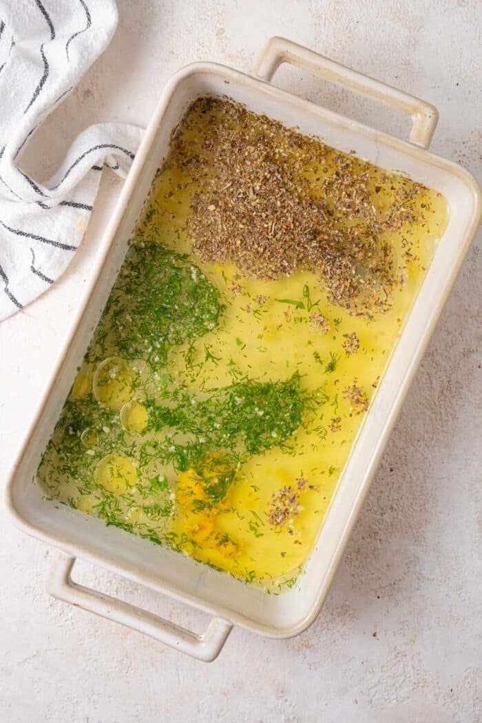 Vegetable broth, olive oil, lemon juice, minced garlic, dried herbs, mustard and salt in a casserole dish.