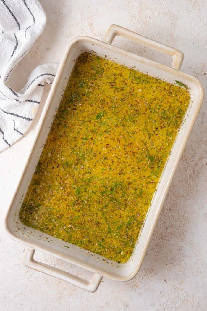Greek potatoes roasting mix in a casserole dish.