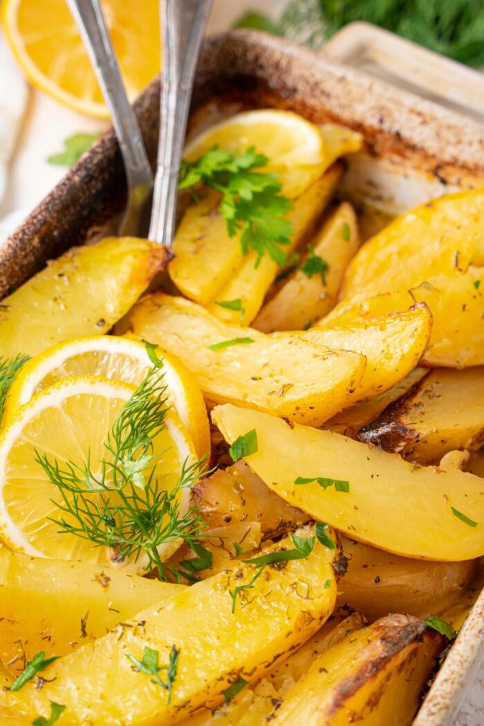 Close up of Greek potatoes served in the casserole dish.