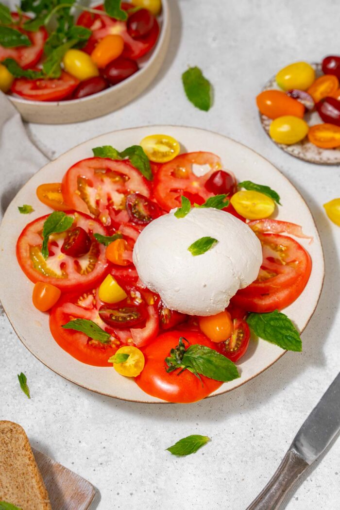 Vegan burrata served at the center of heirloom tomato salad.