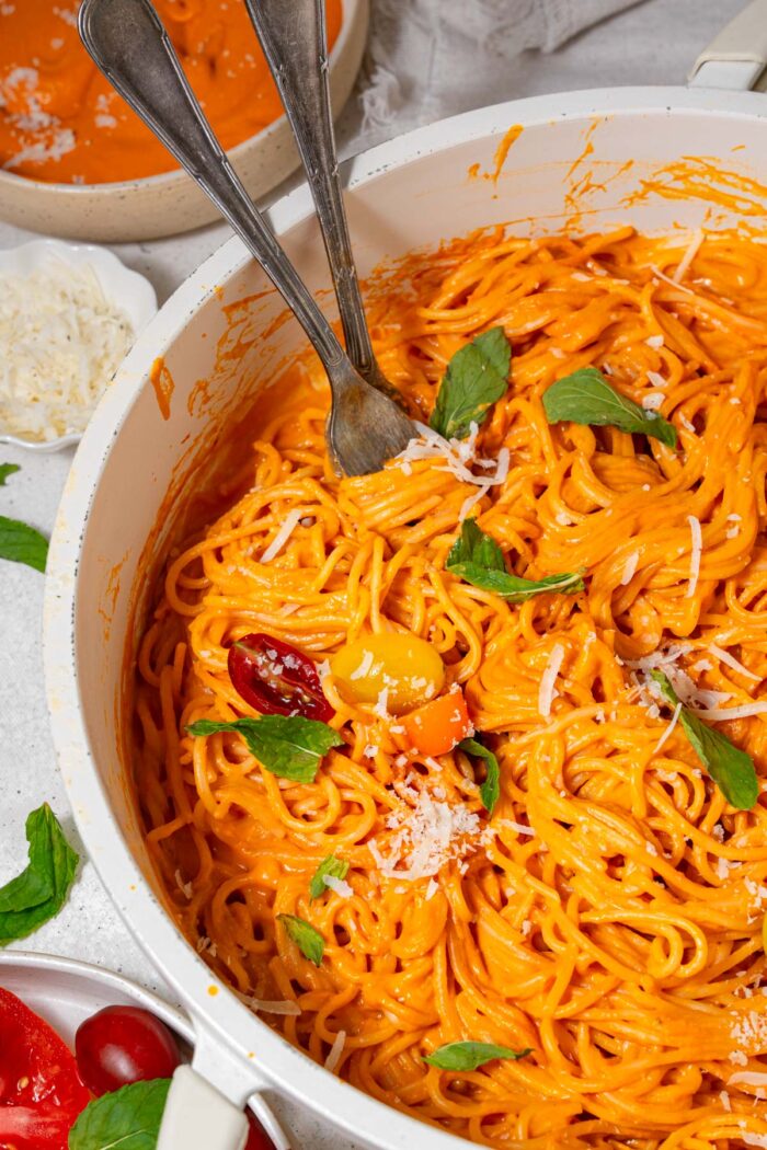 Roasted red bell pepper sauce with spaghetti, basil, and vegan parmesan.