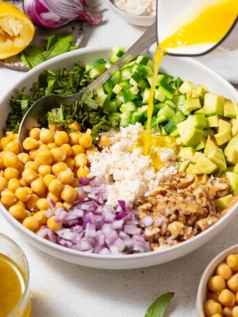 Lemon vinaigrette drizzled over the cucumber chickpea salad ingredients.