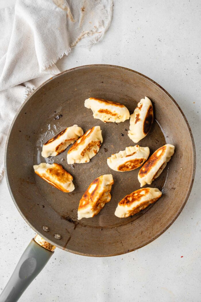 Vegetable dumplings in a frying pan.