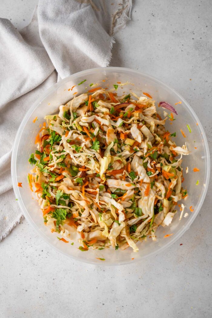 Dumpling salad mixed together in a large see-through bowl.