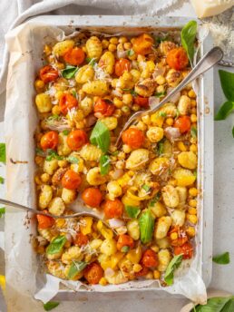 A sheet pan full of vegetable gnocchi with a fork sticking out.