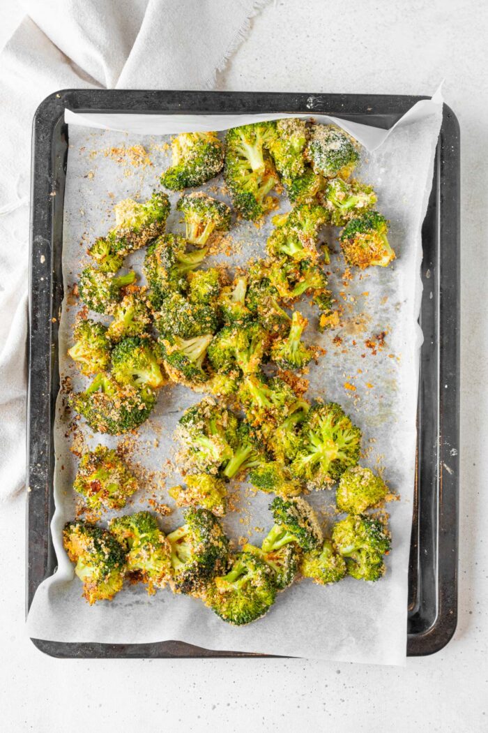 Baked broccoli on a sheet pan, with cornflake crumbs and spices.